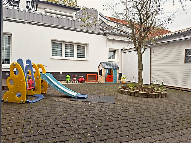 Innenhof mit Rutsche, Schaukel und Spielhaus
